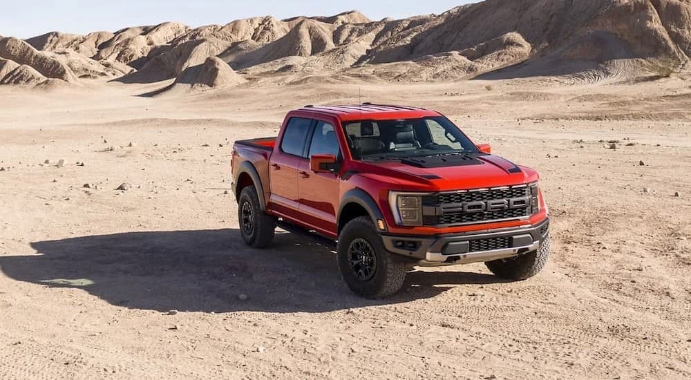 A red 2023 Ford F-150 Raptor parked off-road after viewing a used Ford for sale.