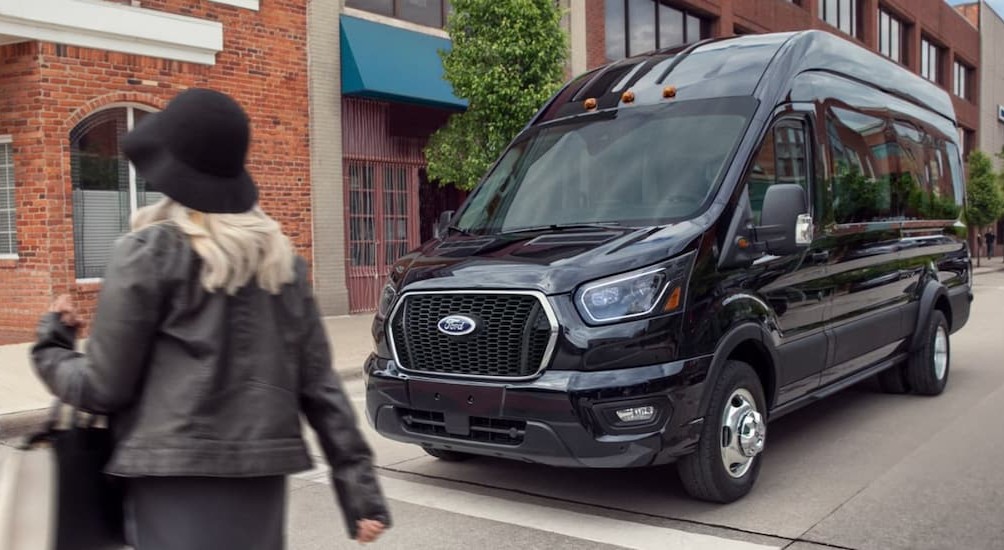 A black 2026 Ford Transit Van stopped at a stop sign.