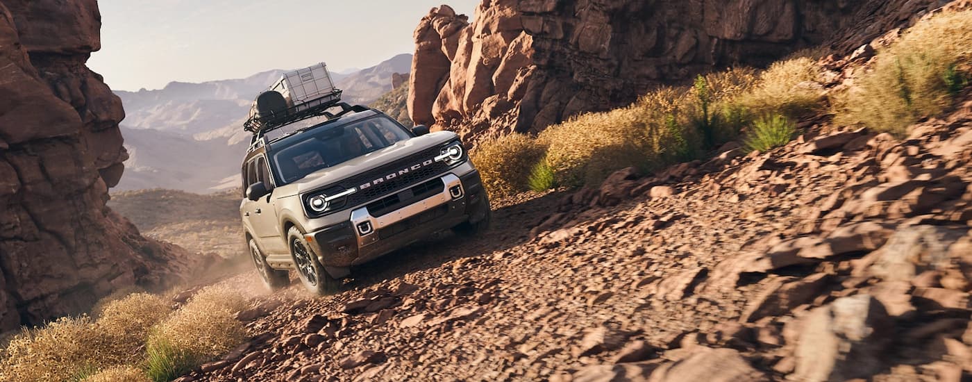 White 2026 Ford Bronco Sport driving off-road up a hill.
