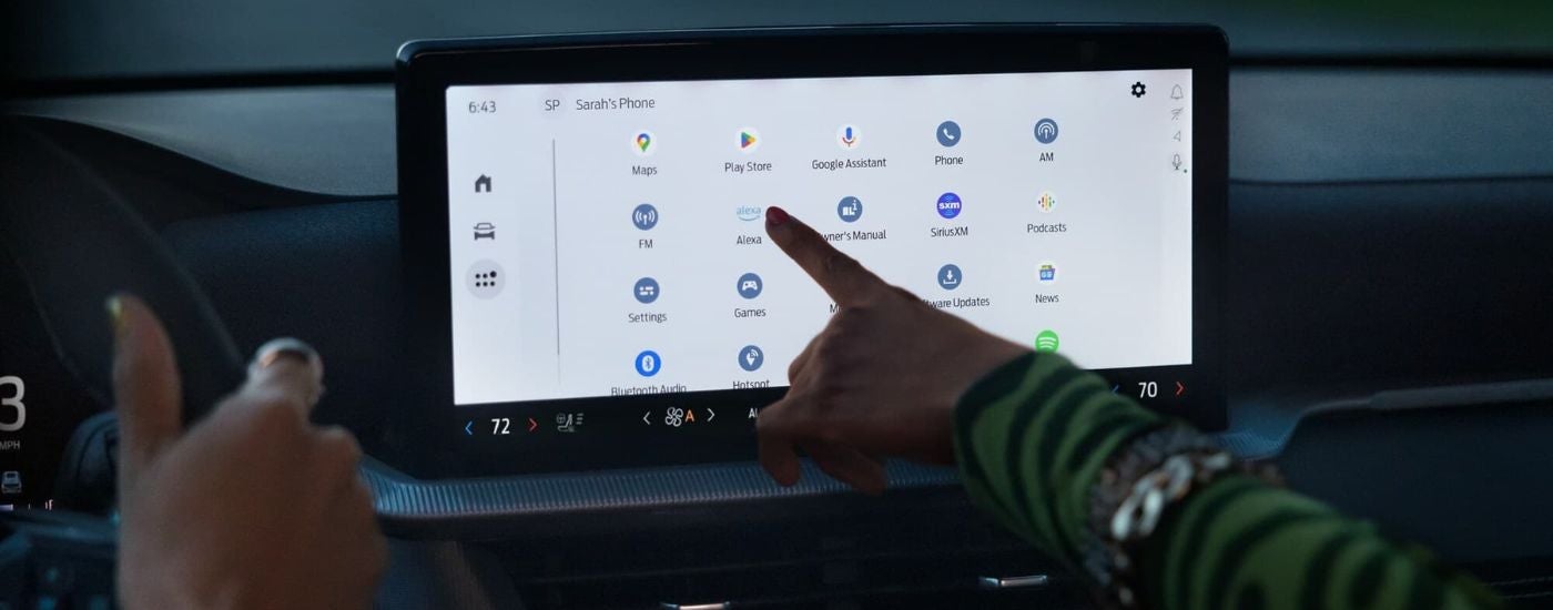 Person using the infotainment touchscreen in a 2025 Ford Explorer