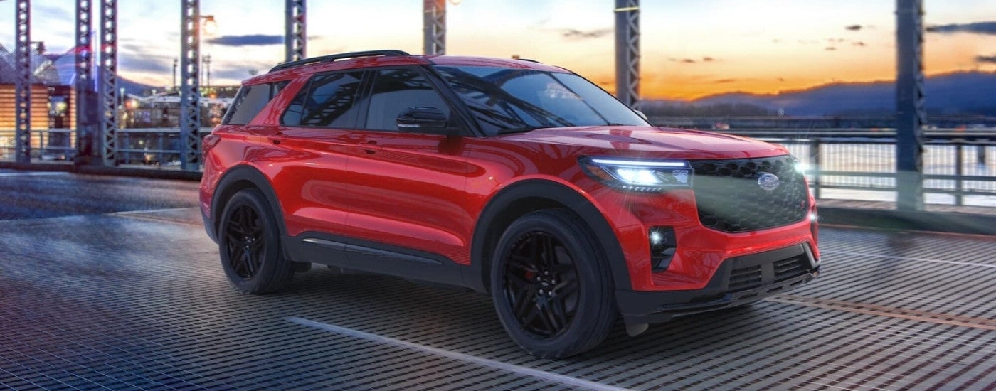 Red 2025 Ford Explorer ST driving on a highway bridge
