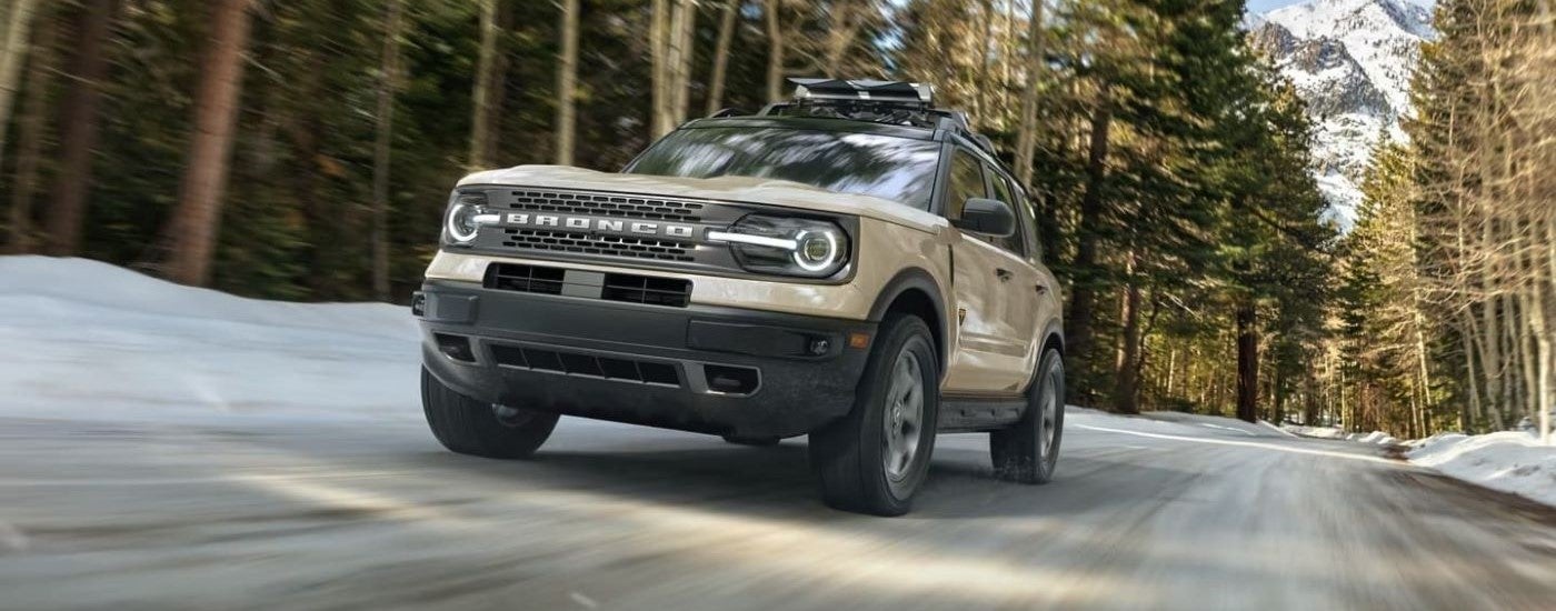 Tan 2026 Ford Bronco Sport Badlands driving down a road.