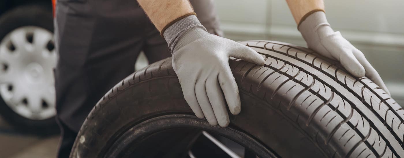Close-up on a mechanic rolling a tire.