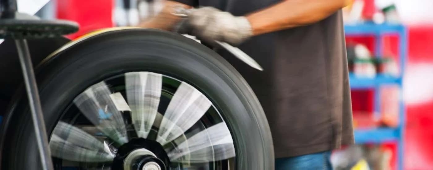 Close-up on a wheel being rotated in a tire shop.